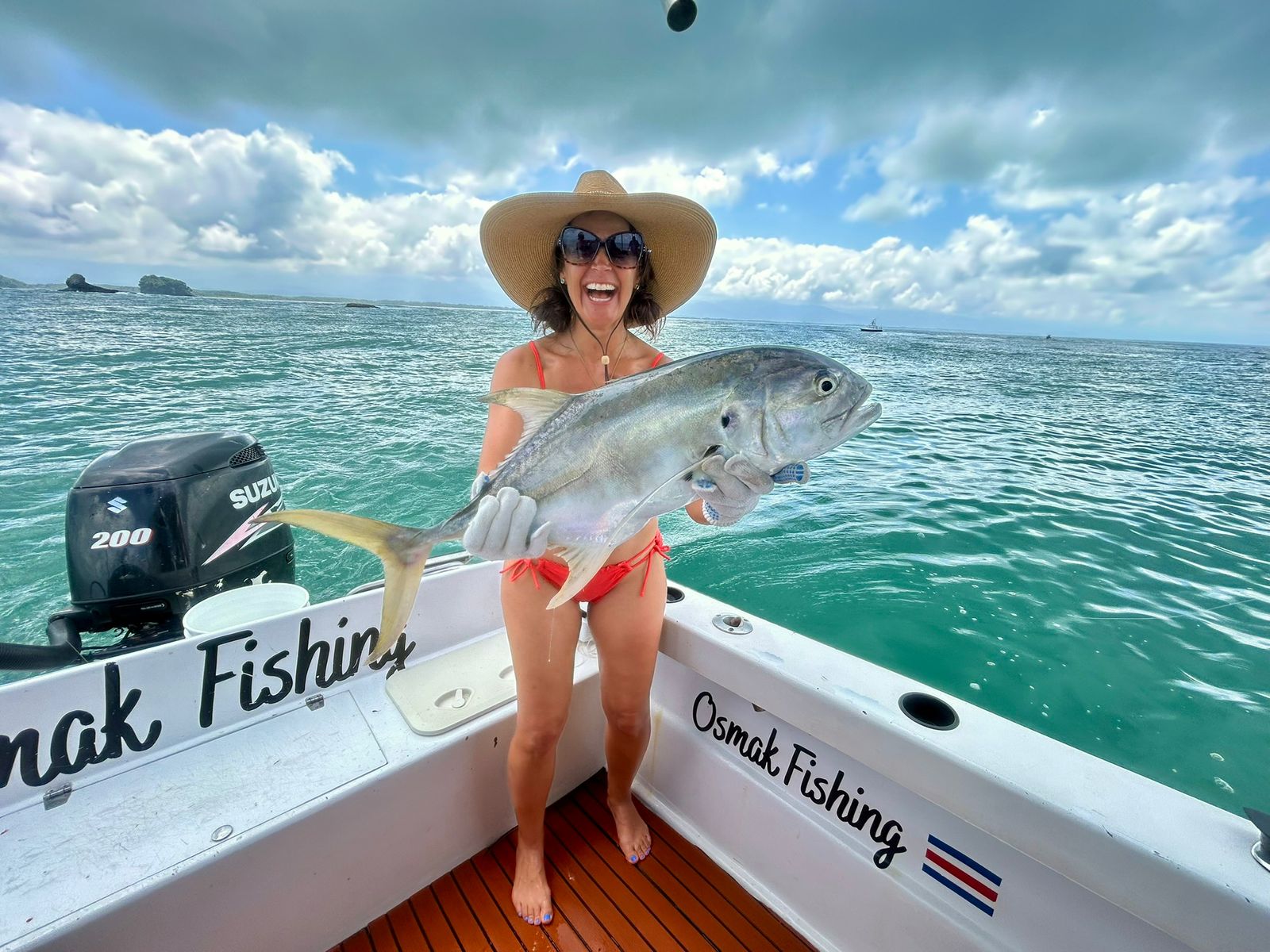 Woman with jack crevalle on turquoise waters